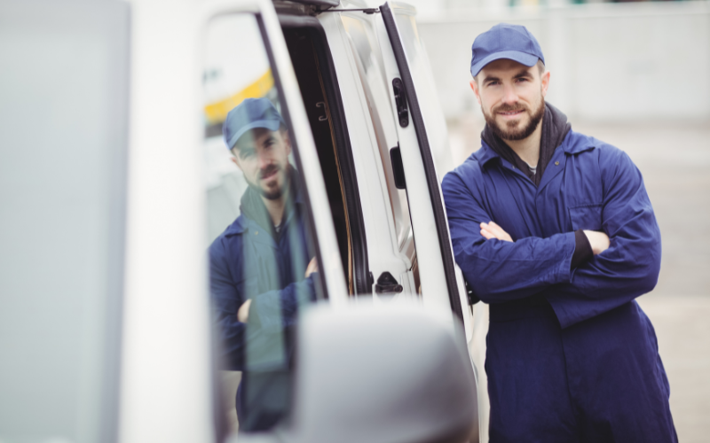 Delivery driver leaning against van